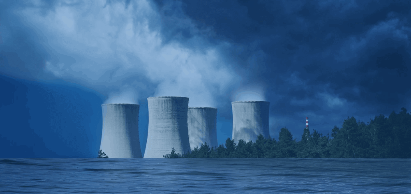 Four natural-draft hyperbolic cooling towers venting plume against a dark storm sky